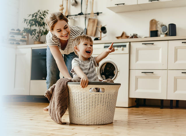 Boy laughing sitting in a laundry basket