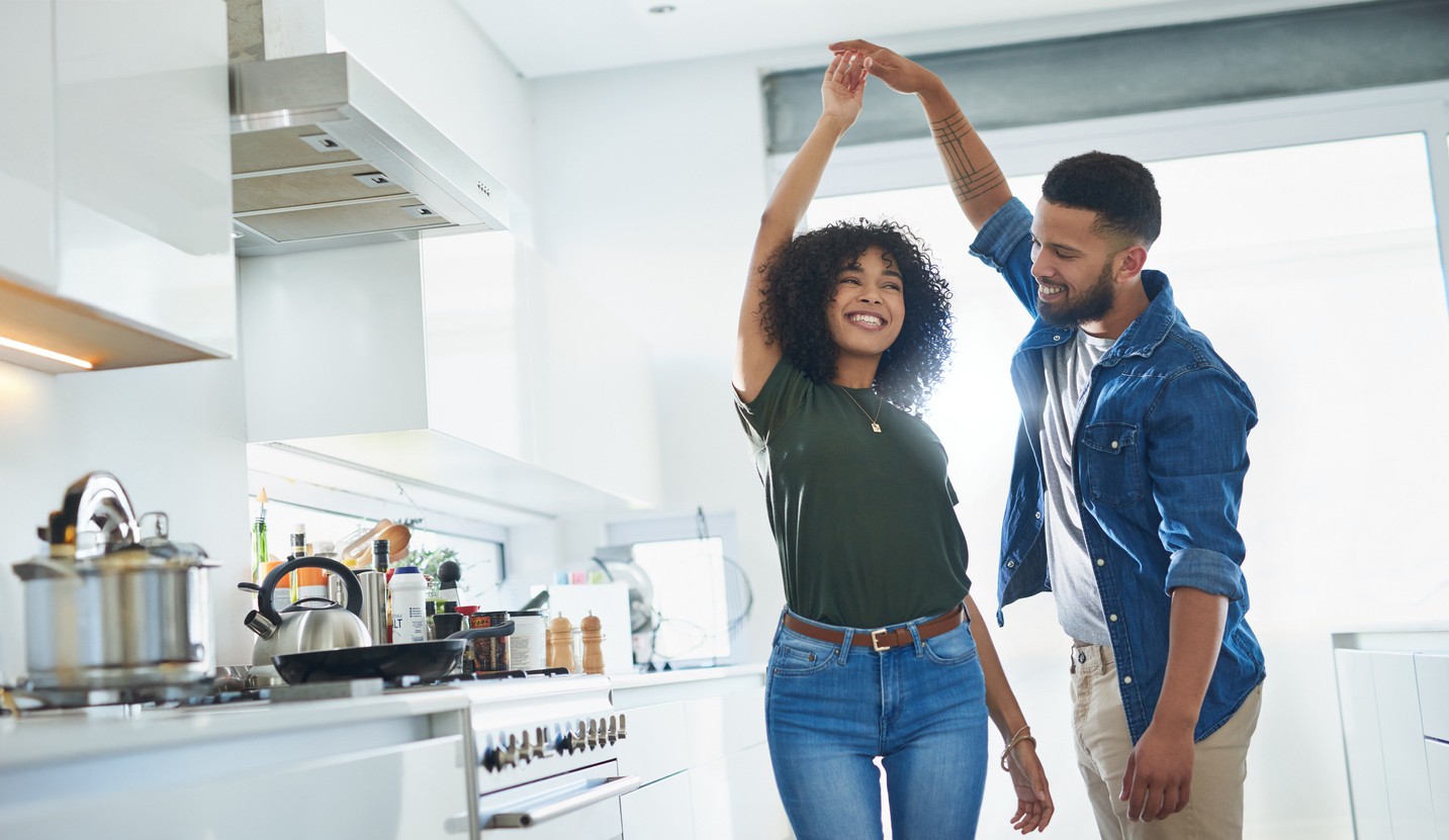 couple laughing and dancing in kitchen